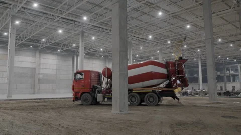 A busy construction site with a concrete mixer in a warehouse, emphasizing Stock Footage 292049161