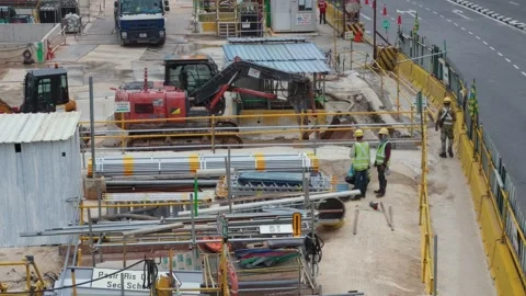 A busy construction site featuring active road works, heavy machinery, building Vídeos de archivo 347036920