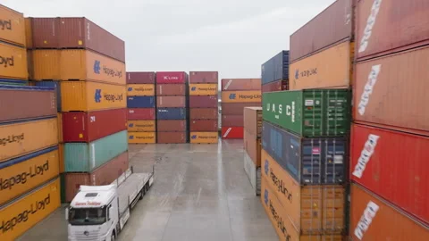 A busy container port featuring towering stacks of cargo containers and trucks 動画素材 318921769