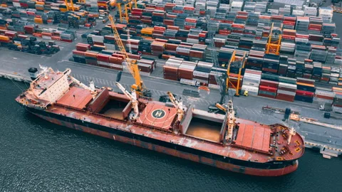 Busy container port loading and unloading cargo ship, aerial hyperlapse Stock Footage