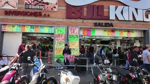 Busy Crowds of shoppers and rows of delivery motorbikes gathered outside the Stockbeeldmateriaal 336731701