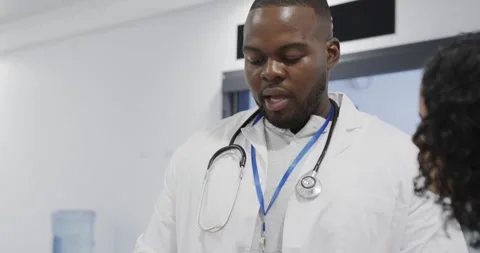Busy diverse doctors using tablet and talking in hospital in slow motion Stock Footage 335866317