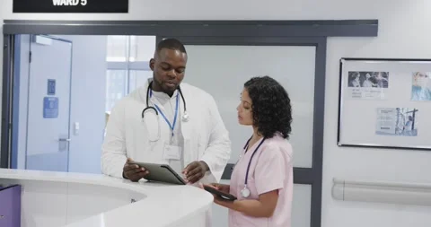 Busy diverse doctors using tablet and talking in hospital in slow motion Stock Footage 337025188