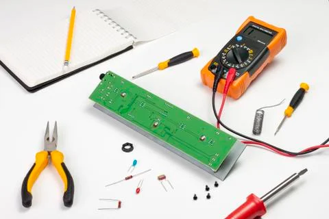 Busy electronics engineers workstation showing a pcb and tools Stock Photos
