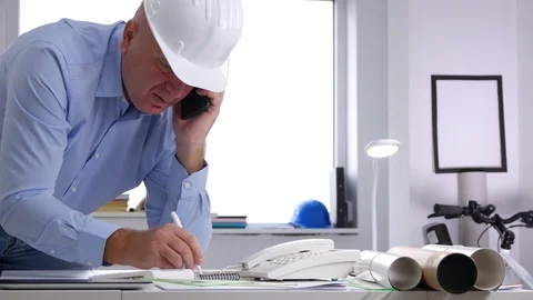 Busy Engineer Talk to Cellphone and Make Calculation Using Adding Machine Stock Footage 97406645
