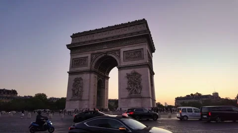 Busy evening traffic surrounding Arc de Triomphe in central Paris Stock Footage 339914695