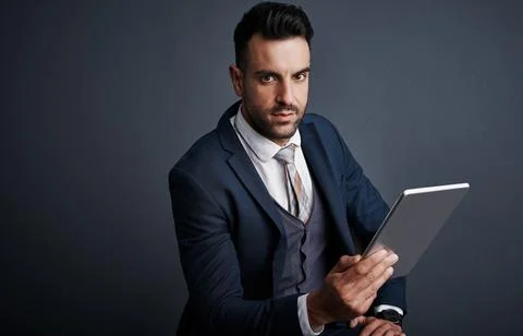 As a busy exec, wireless tech optimizes my time. Studio shot of a stylish young Stock Photos