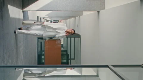 Busy executive manager walking on office talking phone vertically oriented shot Stock Footage 247286407