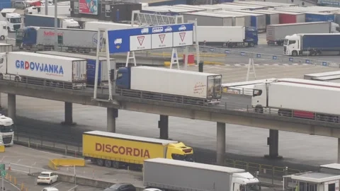 Busy Freight Terminal and Logistics Hub with Semi Trucks Driving Along Elevated Stock Footage 346777096