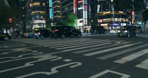 Busy Ginza intersection at night with blurred car traffic, neon lit skyscrapers Stock Footage 334838749