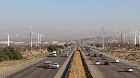 Busy highway interstate valley wind turbine farm Stock Footage 124375196