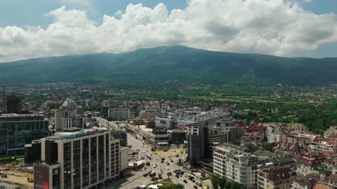 A busy intersection in a big city with a mountain in the background. Timelapse Stock Footage 197147532