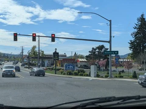 Busy intersection with red traffic lights and a “Welcome to Creswell” Stock Photos