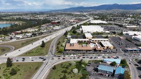 Busy intersection with stopped traffic sits beside retail shopping centers in Video stock 338967525