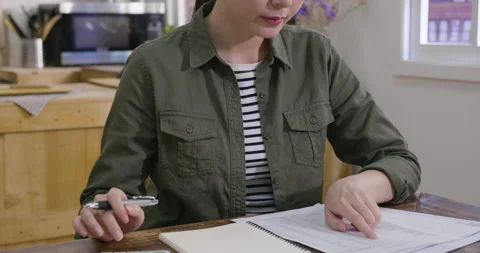 Busy lady at home using calculator and document Stock Footage 133398174
