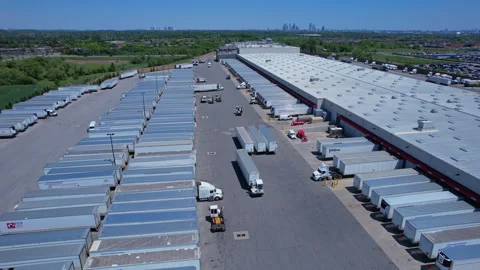 Busy logistics distribution hub with shipping containers at loading dock doors Vidéo 336512802