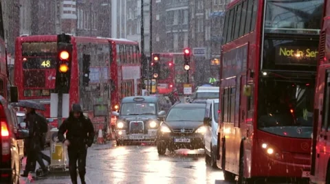 Busy london traffic in the snow at dusk in winter Stock Footage