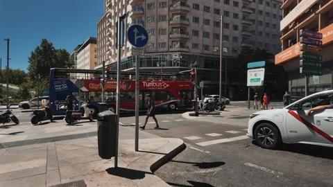 Busy Madrid intersection with buses, taxis, scooters and traffic near Plaza de 스톡 동영상 346127975