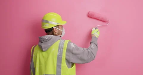Busy man construction worker does wall painting moves actively makes repair in Stock Footage 155489436