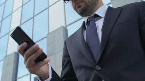 Busy man in suit typing message on smartphone using mobile business app outdoors Vídeo Stock 117222430