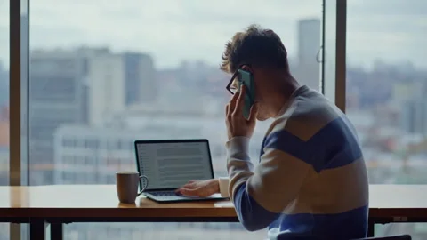 Busy manager talking mobile phone cityscape office closeup. Guy typing computer Stock Footage 335247749