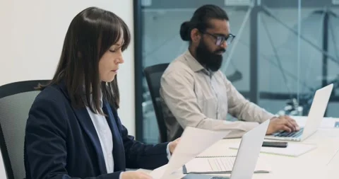 Busy Managers Working on Laptops at Desk in Modern Office Stock Footage 250273820