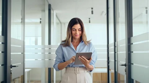 Busy middle aged professional business woman using tablet walking in office. Stock Footage 272215821