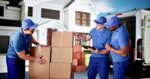 Busy Mover Unloading Van, Carrying Boxes in Front Stock Photos