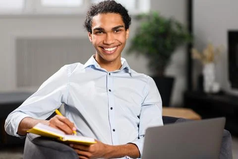 Busy multi-ethnic freelancer guy using laptop computer for work or studying on 写真素材