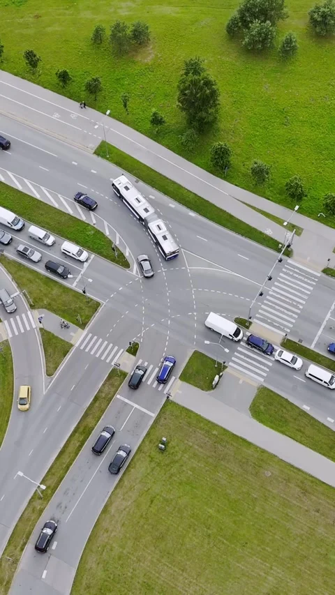 Busy Multilane Intersection With Cars and Bus Crossing Green Areas Видео 345095319