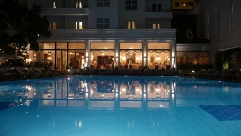 Busy poolside restaurant reflected on swimming pool at the luxurious Copacabana Stock Footage 104865847