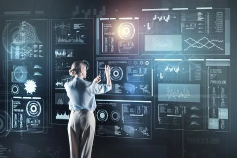Busy programmer standing in front of a transparent screen and looking thoughtful Stock-Fotos