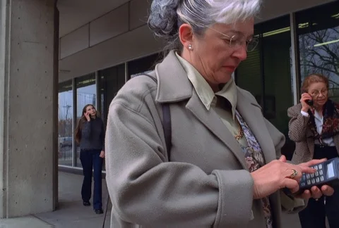 A busy sidewalk outside under an office building's overhang is filled with Stock Footage 86773329
