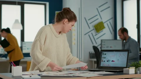 Busy startup employee looking at papers with business data comparing numbers Stock Footage 219585309