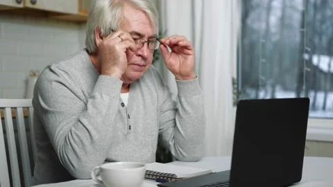 Busy Tired Old Man Using Laptop working from home. Stressed Older Man Stock Footage 234406961