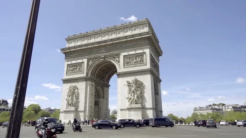 Busy traffic circle at Arc de Triomphe famous monument - cars motorcycles Paris Stock Footage 93812325