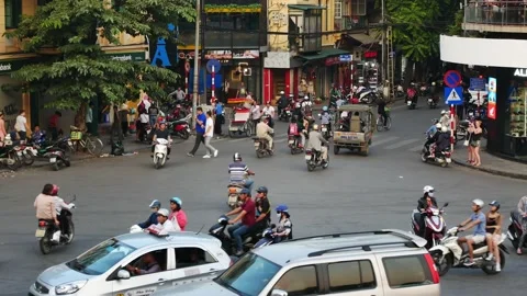 Busy traffic in an intersection with many motorbikes and vehicles in Hanoi. 動画素材 132144682