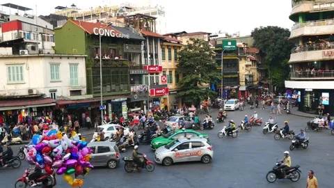 Busy traffic in an intersection with many motorbikes and vehicles in Hanoi. 動画素材 132144833