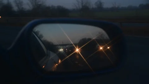 Busy traffic reflected in wing mirror at twilight on dual carriageway  uk Stock Footage 123345649