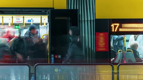 Busy tram stop with passengers continuously boarding and exiting arriving trams Stock Footage 323972676