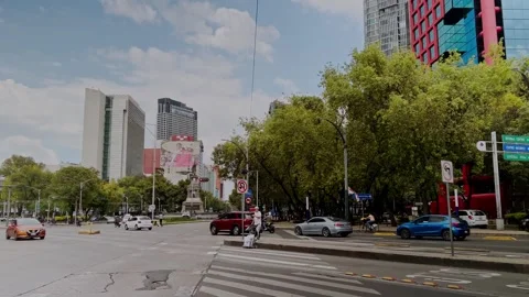 Busy Urban Intersection with Modern Buildings Trees and Traffic in Mexico Stock Footage 346799189