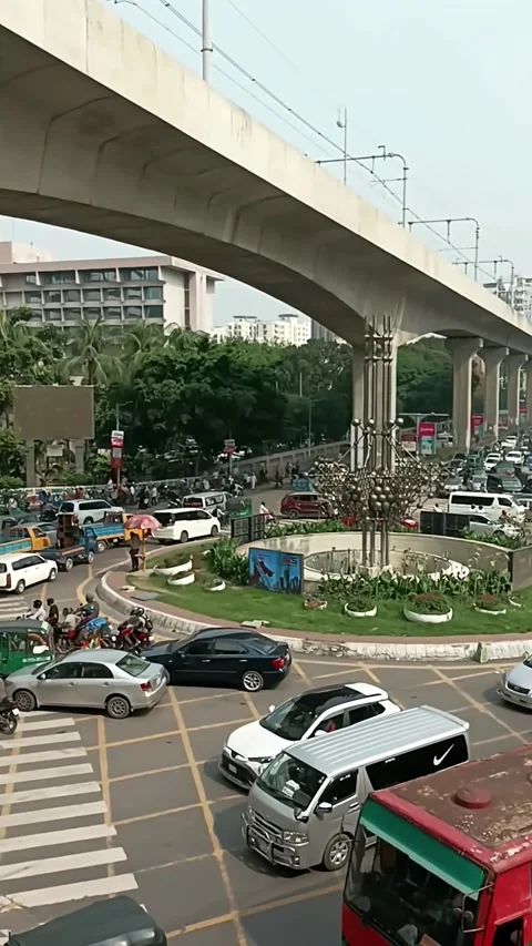 Busy urban traffic intersection with elevated metro rail track in Kawran Bazar Stock Footage 335221875