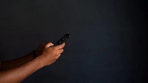 Busy using mobile phone with dark background and a copyspace Stock Footage 127970326