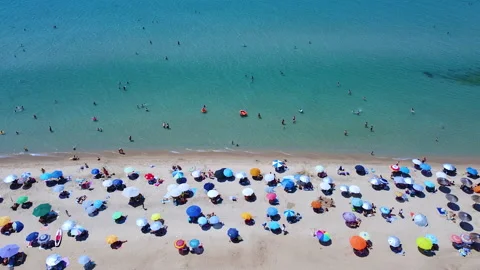 Busy weekend day on the beach. sandy beach full with tourists 스톡 동영상 135830132