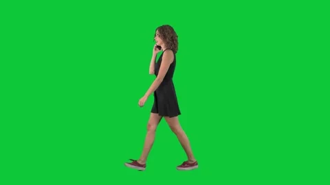 Busy woman walking and talking on the phone full body side view on green screen Stock Footage