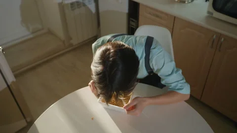 Busy worker indulges in warm snack during work stress. Kitchen scene shows Stock Footage 337234097