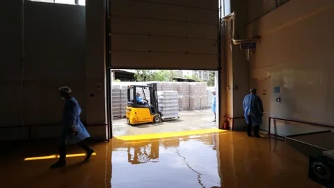 Busy Worker In A Warehouse Or Factory Using A Forklift Truck To Move Boxes Stock Footage 153027828