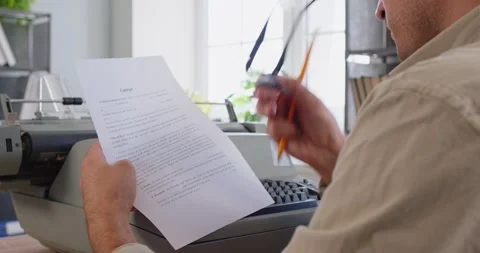 Busy writer reading paper document typing on old typewriter at office desk Stock Footage 327023562