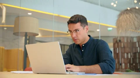 Busy young business man using laptop computer working sitting at office desk. Stock Footage 273062524