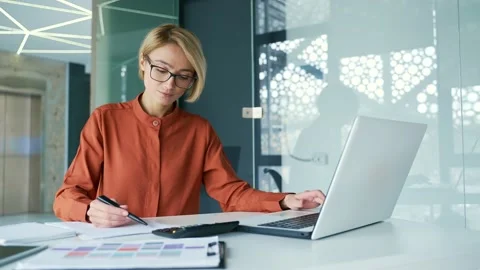 Busy young female manager preparing for presentation while sitting at workplace  Stock Footage 239027016